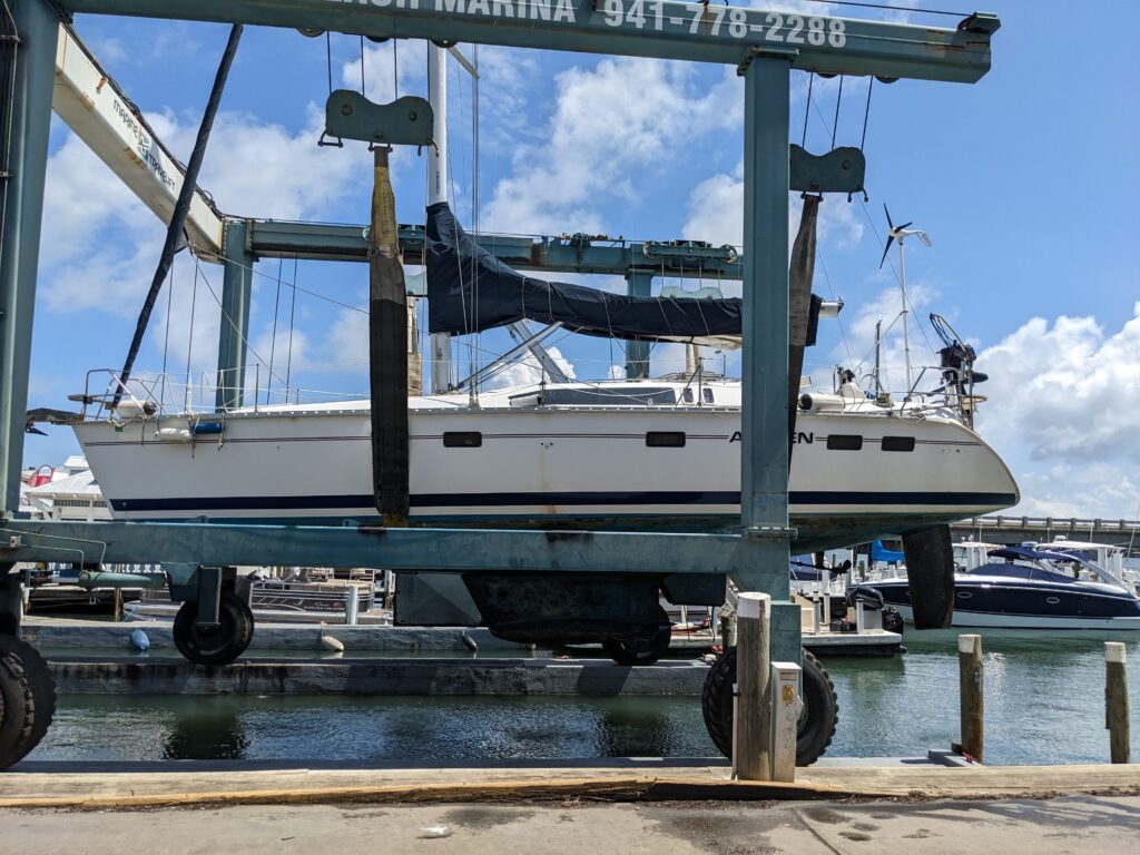 A Hunter sailboat over the water in slings