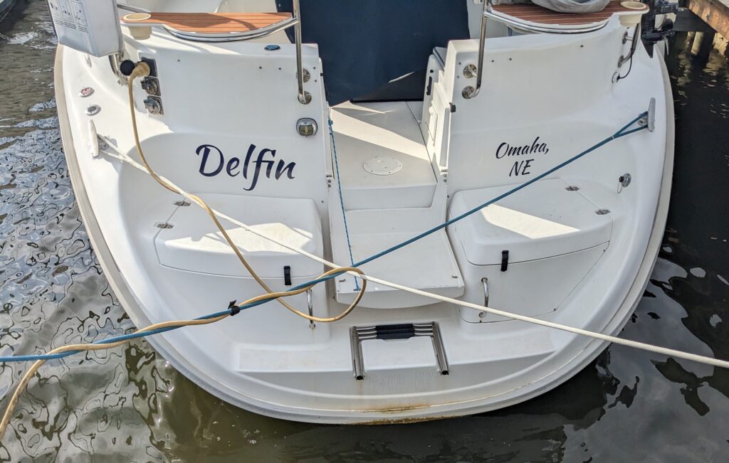 The transom of a sailboat with the name Delfin and port of call Omaha, NE